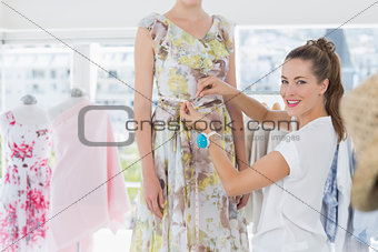 Female fashion designer measuring models waist