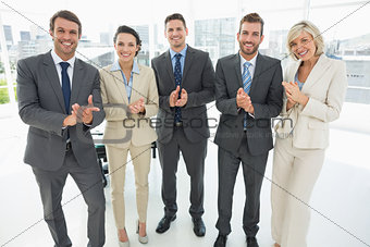 Business team clapping hands together in office