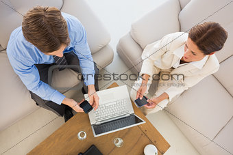 Business team working together on the couch using their smartphones