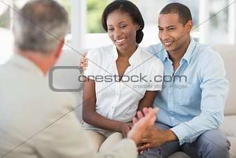 Young couple listening to salesman on the couch