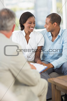Young couple interacting with salesman on the couch