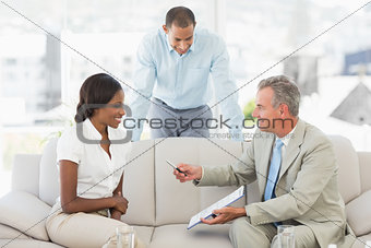 Salesman handing pen to client to sign the paperwork