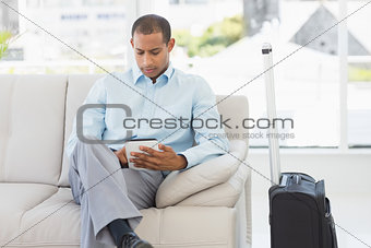 Man sitting on sofa waiting to depart on business trip