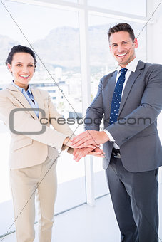 Cheerful business colleagues joining hands together