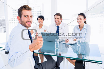 Executive gesturing thumbs up with recruiters during interview