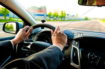 man holds the steering wheel firmly with both hands