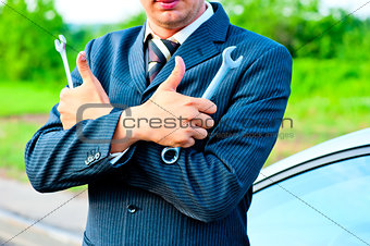 businessman in a suit holding a wrenches