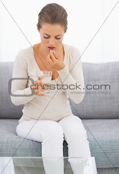 Young housewife eating pills