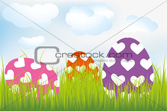 Easter background with heart-decorated eggs in meadow