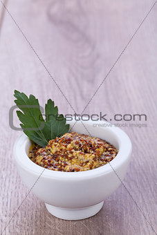 fresh yellow mustard in white bowl with parsley decorated