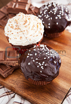 Chocolate cupcakes decorated with glaze and cream