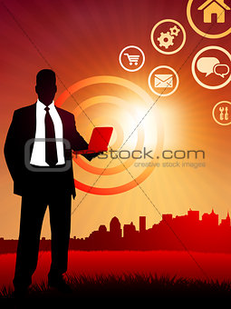 businessman holding computer laptop on sunset background with sk