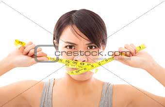 angry woman holding ruler to close mouth