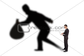 businessman using laptop with thief shadow