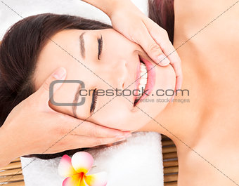 massage of face for asian woman in spa salon