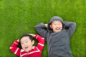  two brothers lying on the meadow in the park