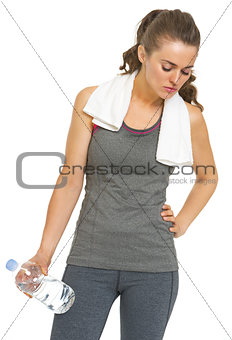 Tired fitness young woman with towel and bottle of water