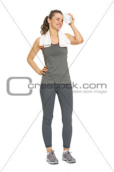 Full length portrait of tired fitness young woman with bottle of