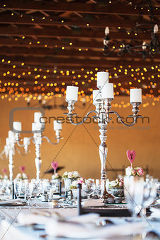 Candelabra with candles on decorated wedding reception tables