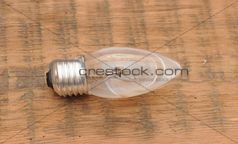 old burned out light bulb on wood background