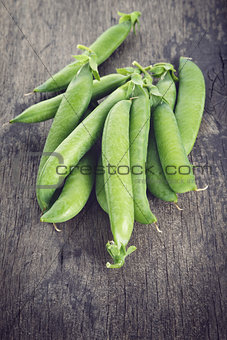 heap of pea pods on old wood table