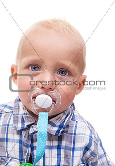 Closeup of cute blonde blue-eyed little boy with a pacifier