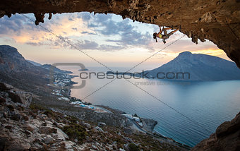 Female rock climber against picturesque view of Telendos Island at sunset. Kalymnos Island, Greece.