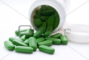 green pills on the white surfase