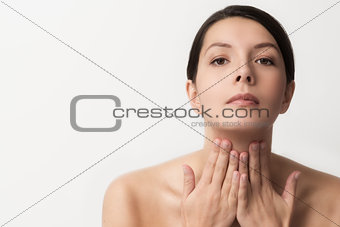 Beautiful woman massaging her throat