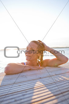 Attractive woman resting at edge pier