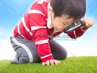 a boy exploring nature with magnifying glass