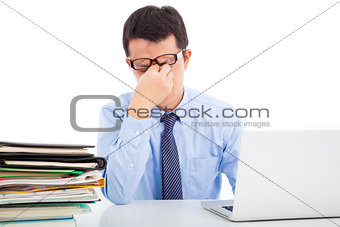 businessman is too overwork to rubbing his eyes 