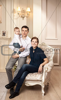 Young happy family with a baby indoors