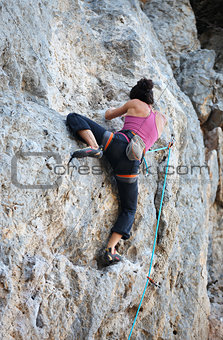 Rear view of young female rock climber on cliff