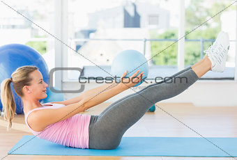 Sporty young woman stretching body in fitness studio