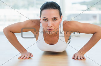 Determined beautiful woman doing push ups in gym