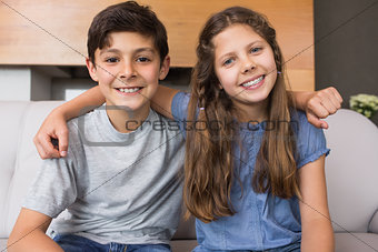 Portrait of smiling little siblings in living room