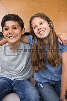 Smiling little siblings in the living room