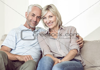 Portrait of smiling mature couple sitting on sofa