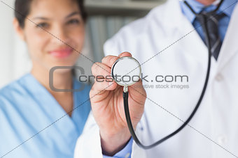 Midsection of doctor holding stethoscope