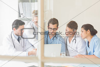 Doctors and nurses discussing over laptop