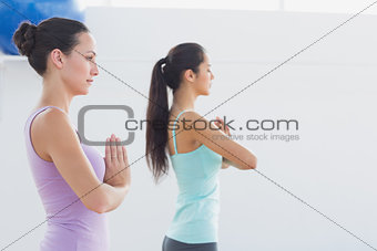 Sporty women with joined hands in fitness studio