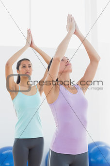 Women with joined hands in fitness studio
