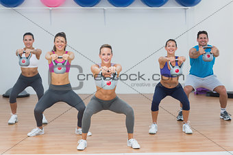 Fitness class exercising with kettlebells in gym