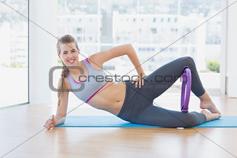 Sporty young woman with exercising ring in fitness studio