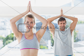 Sporty couple with joined hands in fitness studio