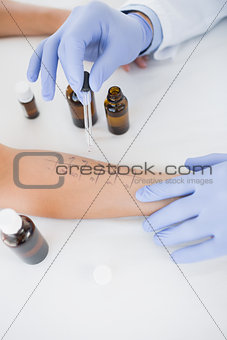 Doctor dropping medicine on hand of patient