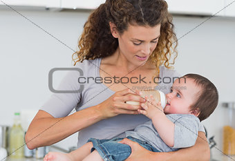 Beautiful mother feeding milk to baby