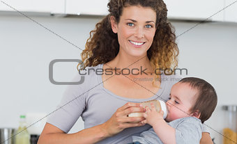 Attractive woman feeding milk to baby