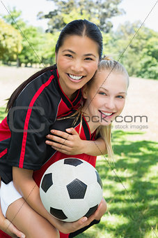 Female soccer player piggybacking teammate